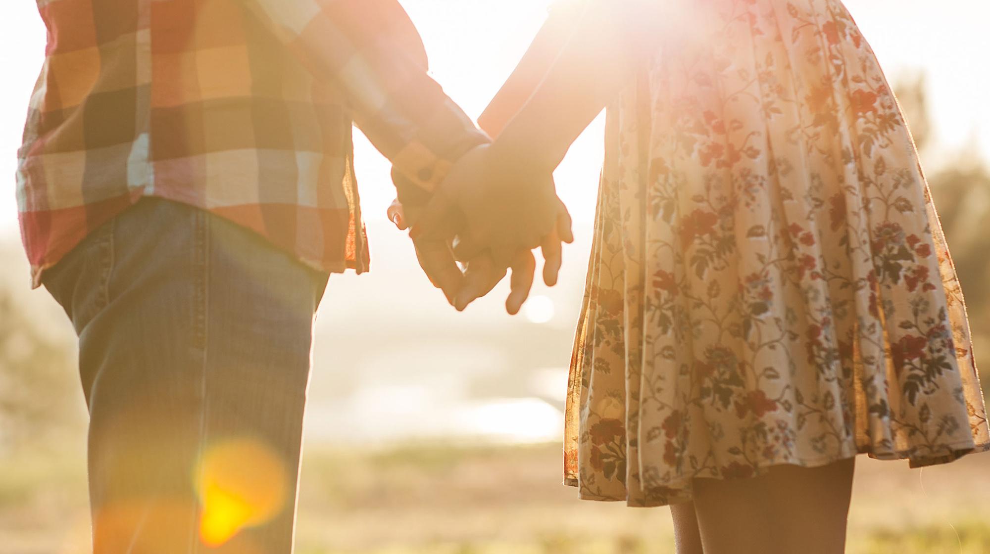 The image display a romantic couple touching hands